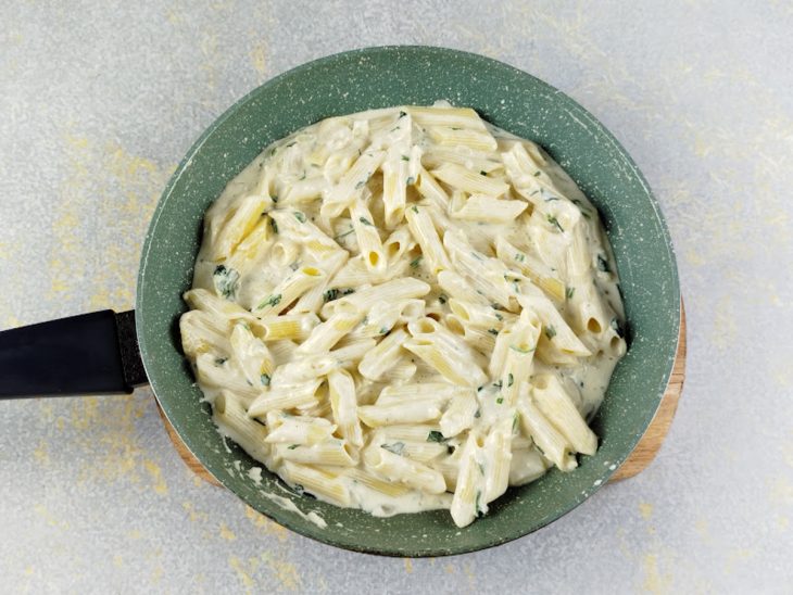 Na panela, o macarrão cozido adicionado a mistura.