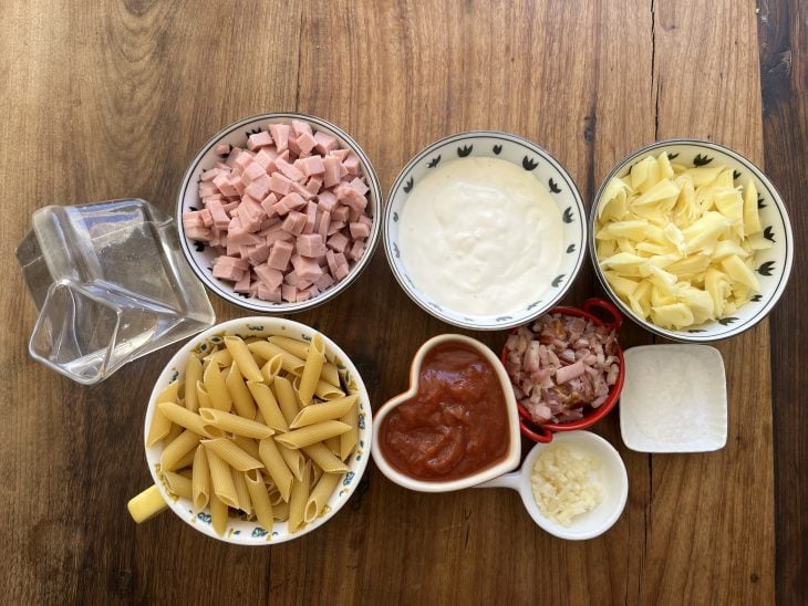 Ingredientes do macarrão cremoso na panela de pressão reunidos na mesa.