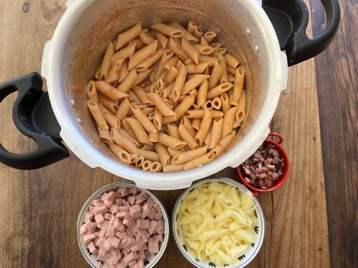 Macarrão cozido na panela de pressão com potinhos cheios de presunto, mussarela e bacon.