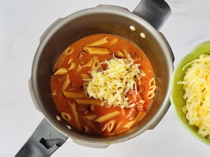 Mussarela ralada colocada na panela.
