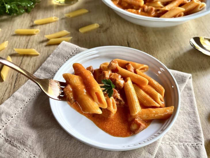 Porção de macarrão cremoso servida num prato individual.