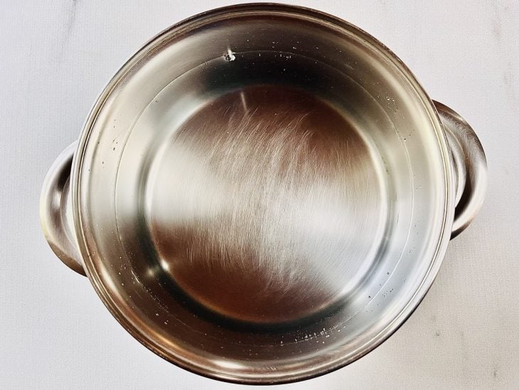 Água esquentando em uma panela com um fio de óleo e sal.