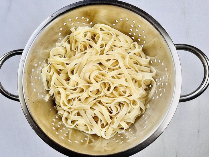 Macarrão cozido em um escorredor.