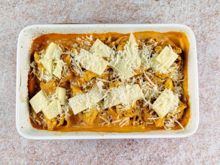 Frango, mussarela e parmesão adicionados no refratário.