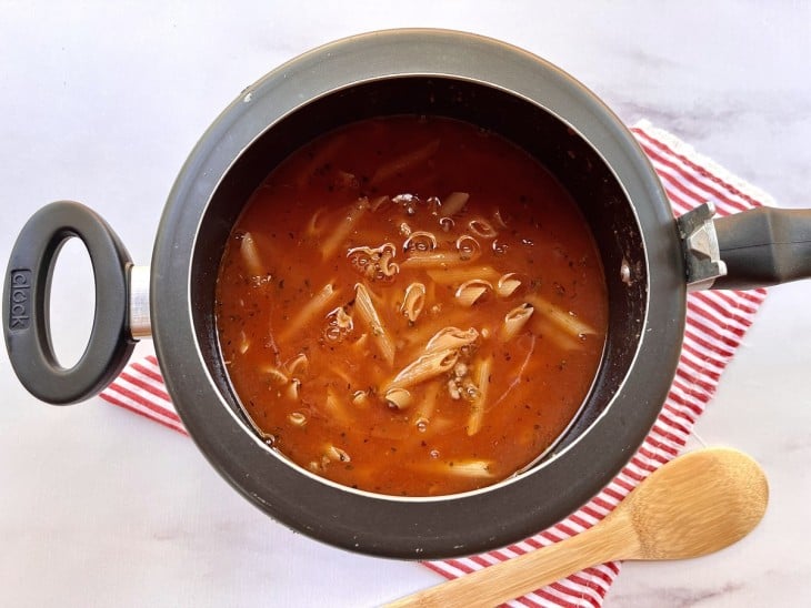 Ingredientes do macarrão na panela de pressão misturados na água.