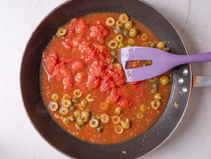 adição de tomate pelado para fazer o molho do macarrão italiano.