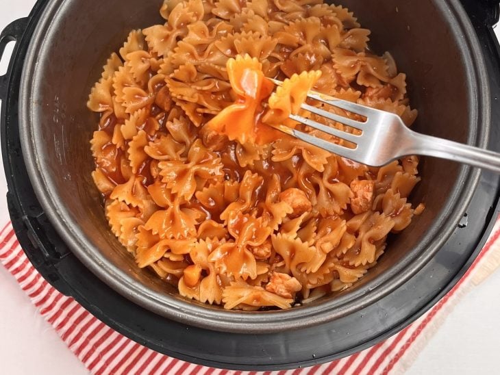 Panela de arroz com massa de macarrão e molho.