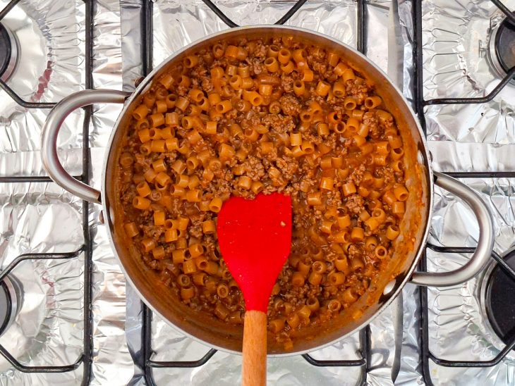 Macarrão adicionado ao molho na panela.