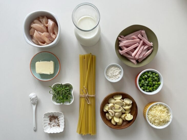 Ingredientes separados na bancada com massa, frango, presunto, champignons, leite e temperos organizados.