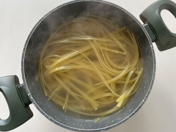Fettuccine sendo cozido em panela com água fervente.