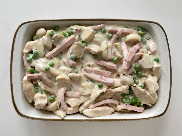Molho parisiense sendo colocado sobre o fettuccine cozido.