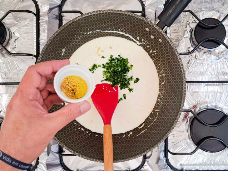 Na frigideira, o lemon pepper sendo adicionado.