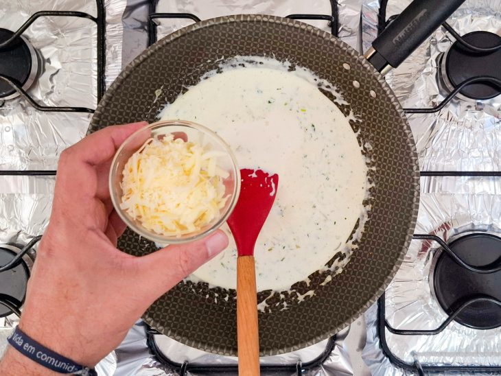 Parmesão sendo adicionado na frigideira.
