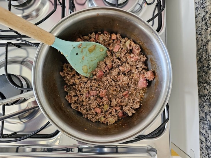 Uma panela refogando a carne moída com extrato de tomate.