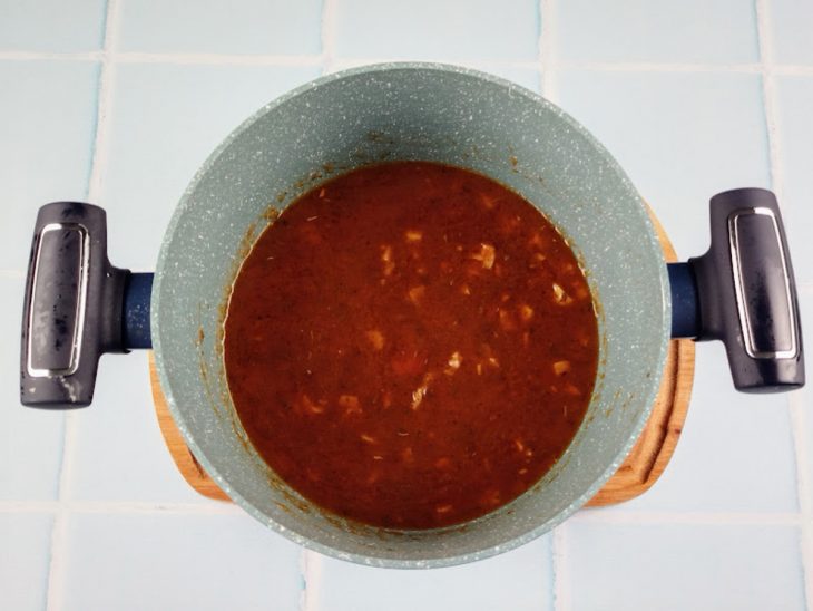 Molho de tomate com temperos na panela.