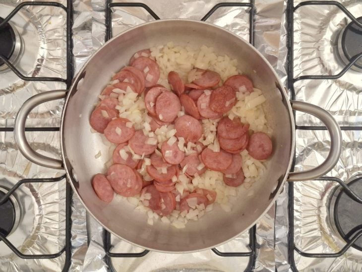 Cebola e extrato de tomate adicionados a panela.