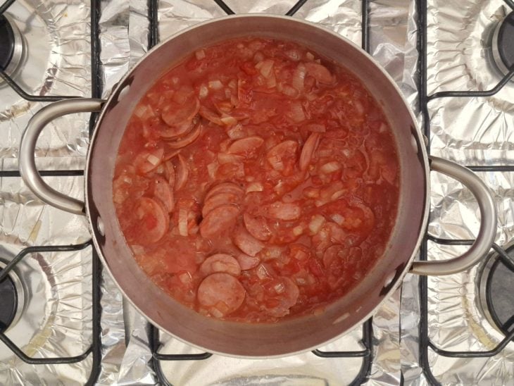 Tomate pelado, páprica, pimenta-calabresa, sal, pimenta-do-reino e água adicionados a panela.