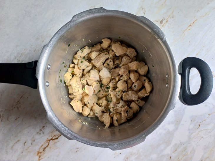 Frango cozido em uma panela de pressão com um fio de óleo.
