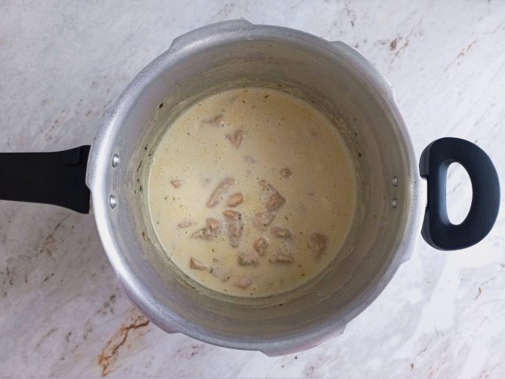 Creme de leite e requeijão adicionados a panela de pressão.