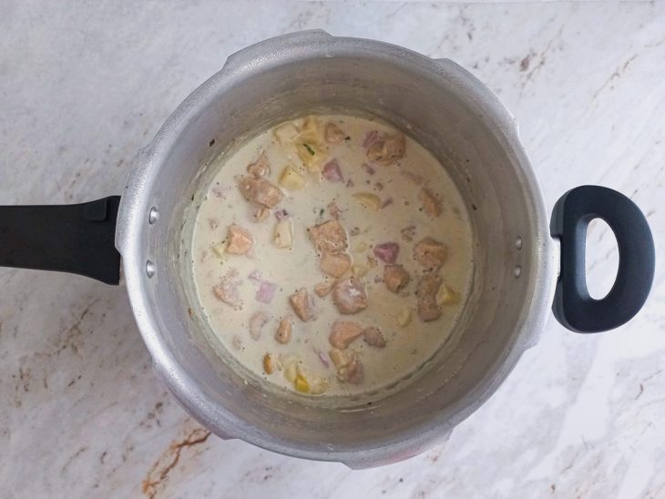 Queijo mussarela, presunto e sal adicionados a panela de pressão.