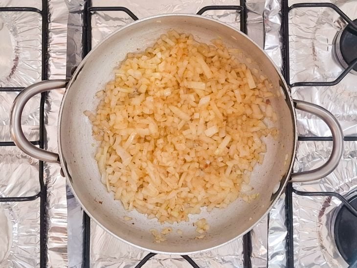 Cebola fritando na mesma panela.
