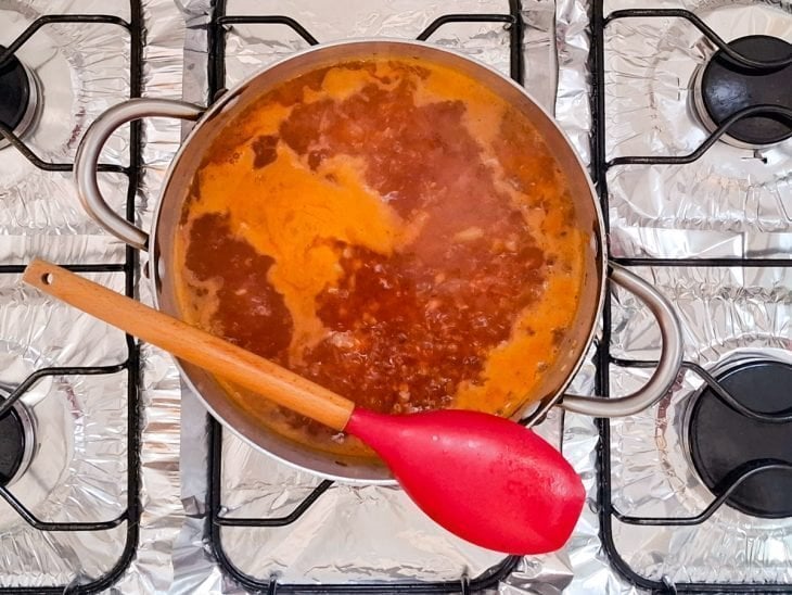 Água do cozimento e bacon adicionados a panela.
