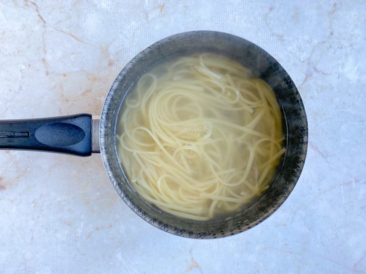 Macarrão em processo de cozimento em uma panela com água.