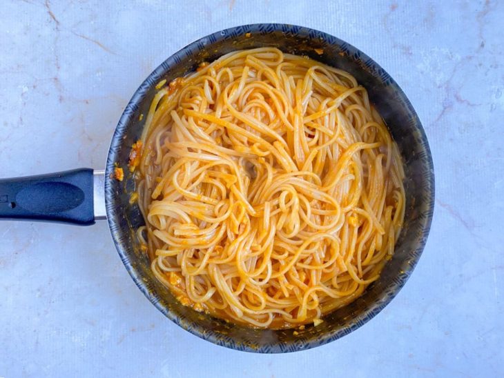 Molho de tomate e água do cozimento, adicionados no macarrão.