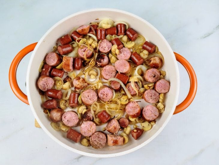 Linguiça toscana, cogumelos e temperos adicionados na panela.