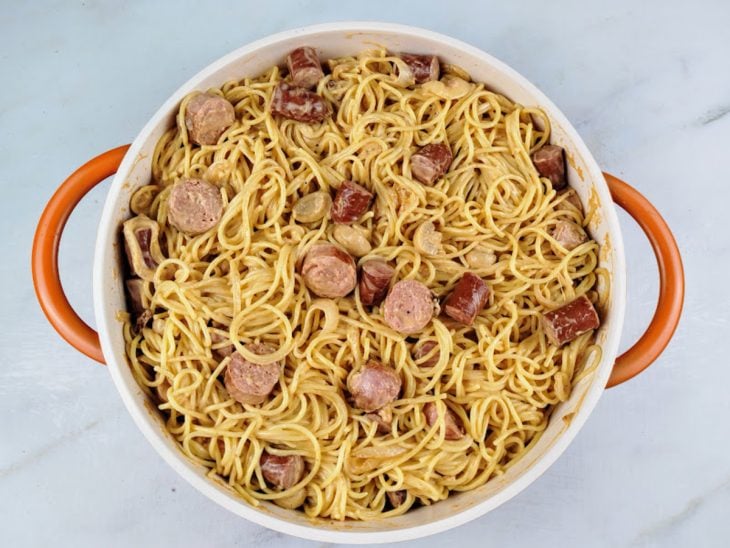 Água do cozimento e macarrão adicionados na panela.