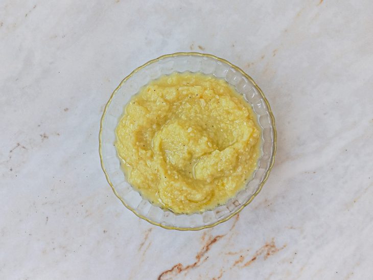 Abobrinha, dentes de alho, levedura, suco de limão, noz-moscada e pimenta-do-reino batidos no liquidificador e molho reservado em um prato.