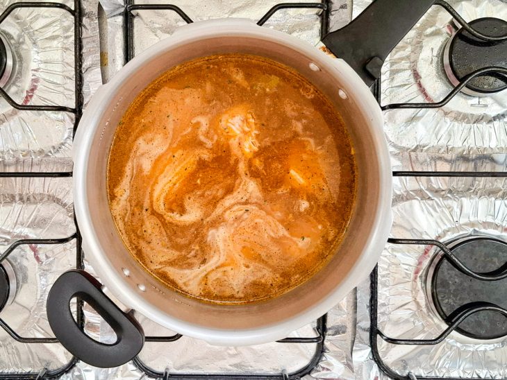 Água e caldo de galinha adicionados a panela.