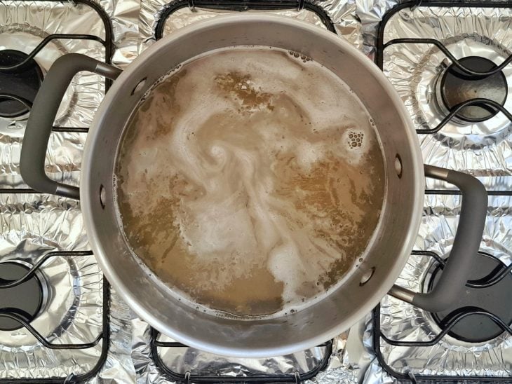 Macarrão cozinhando em uma panela com água, óleo e sal.