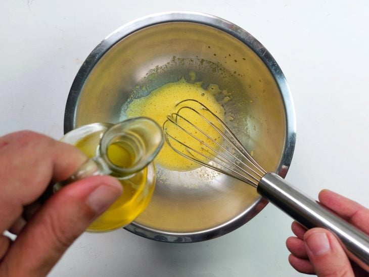 Um recipiente contendo ovos, vinagre, óleo e mostarda.
