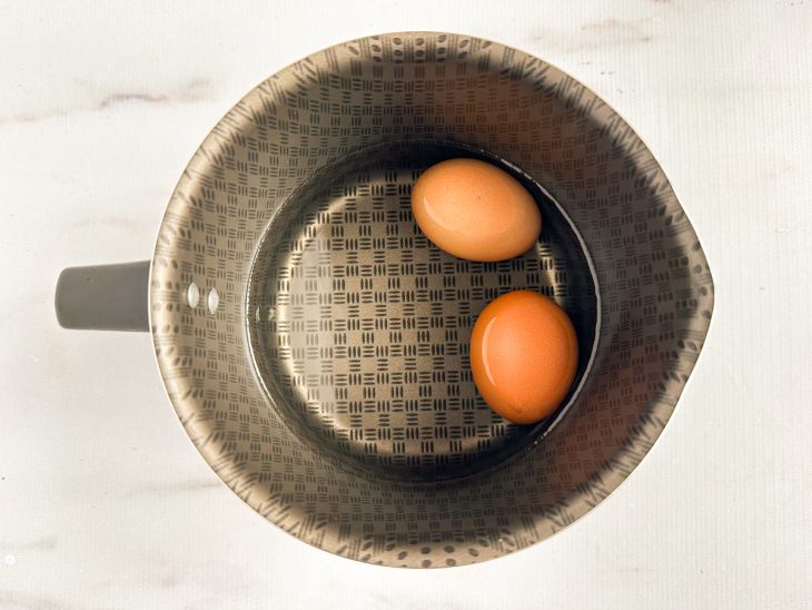 Numa leiteira, os ovos na água.