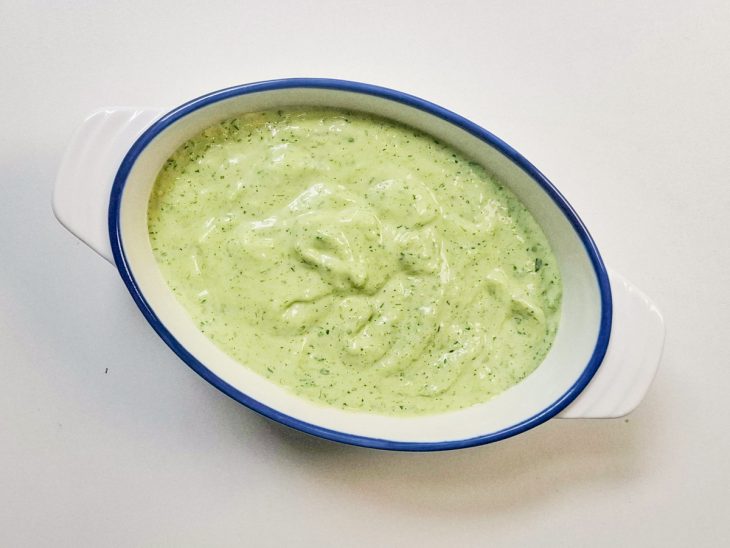 Maionese verde despejada num recipiente.
