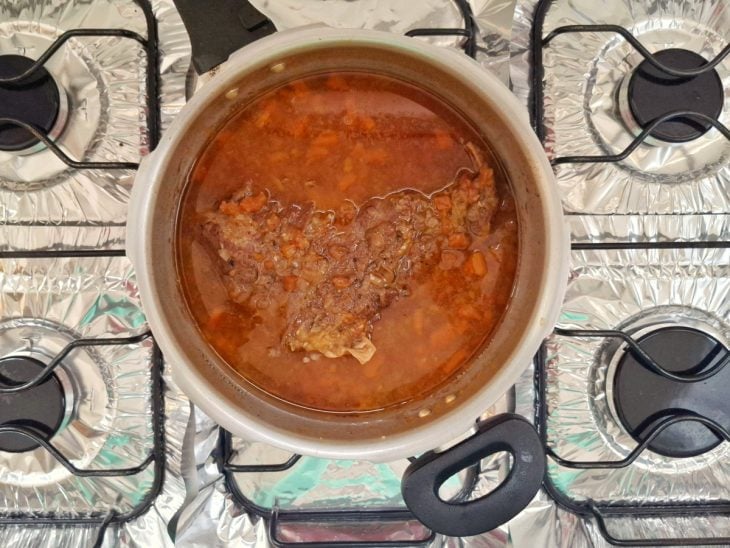 Uma panela de pressão com a maminha e os outros ingredientes após cozimento.