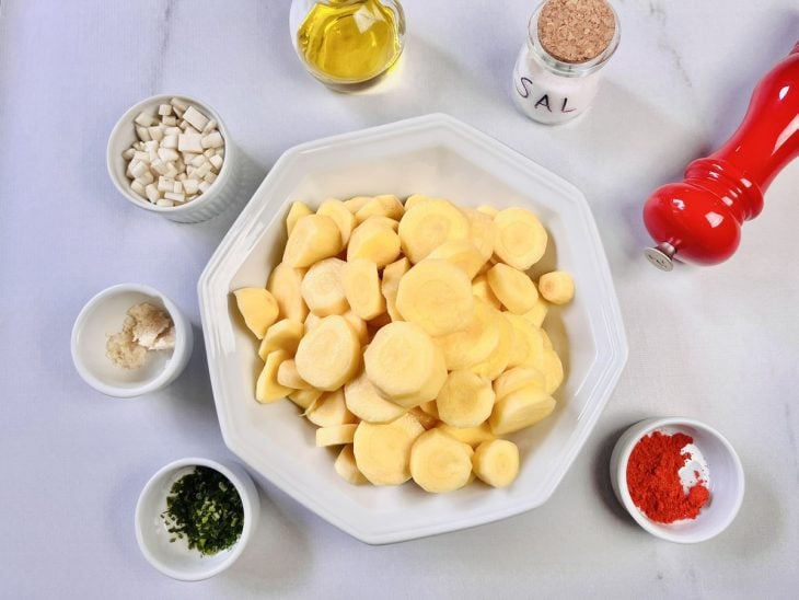 Ingredientes para a receita de mandioquinha fácil e rápida reunidos em uma superfície.