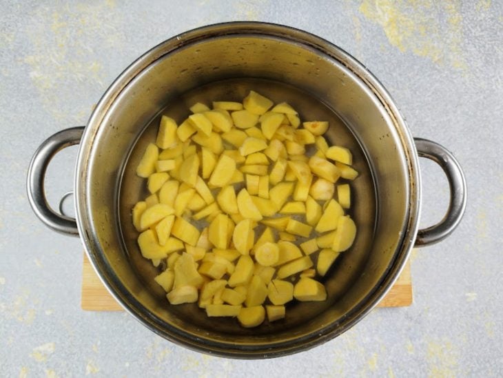 Uma panela com mandioquinha e água.