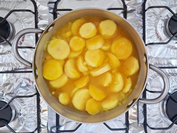 Panela com mandioquinha e o restante dos ingredientes cozinhando na água.