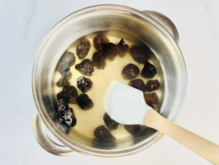 Ameixas, água e açúcar numa panela.