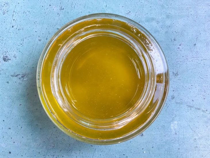Um recipiente contendo manteiga ghee derretida.