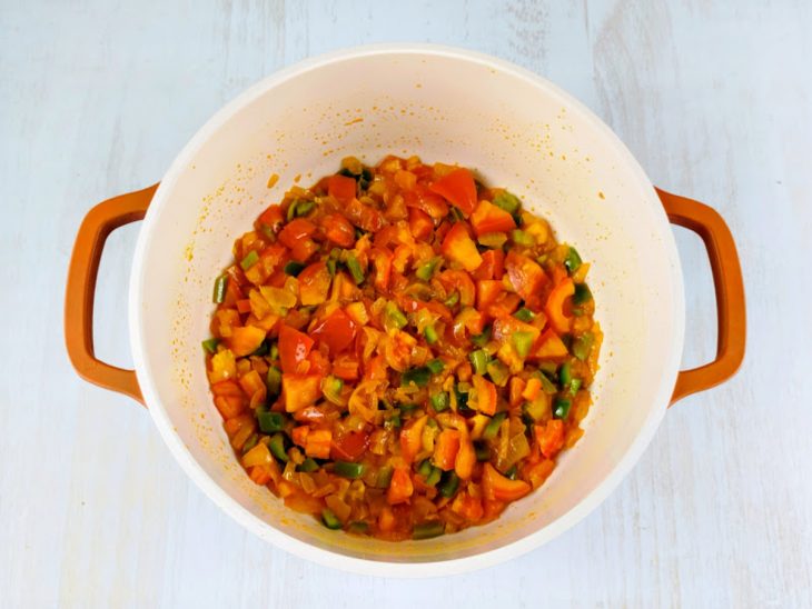 Pimentão e tomates adicionados na panela.