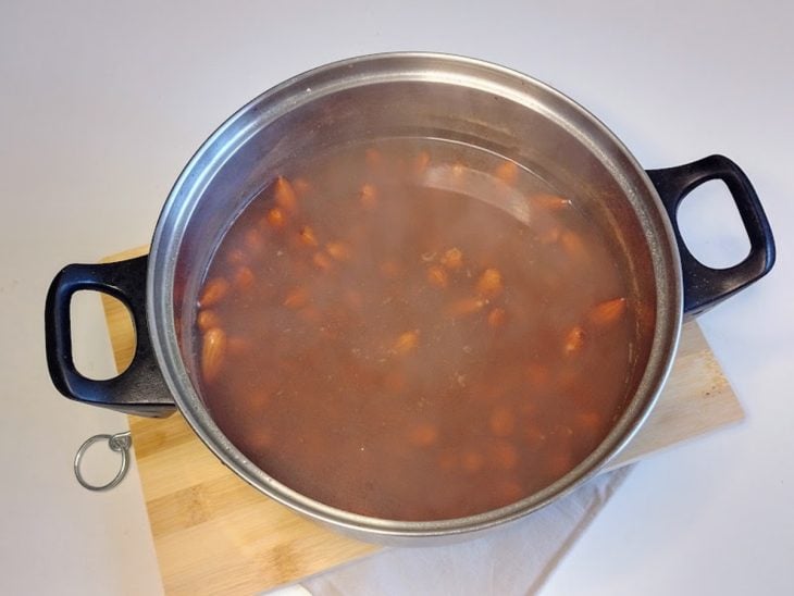 Uma panela com água quente e amêndoas.