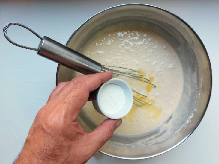 Um recipiente com a mistura da massa com fermento e manteiga.