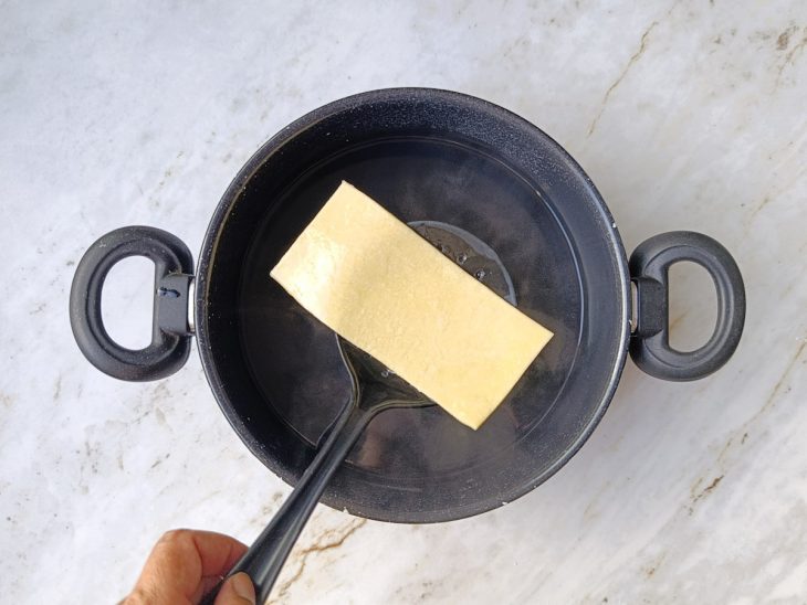 Retângulos de massa sendo pré-cozidos em água fervente.