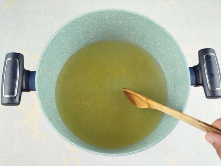 Caldo de galinha dissolvido em água numa panela.