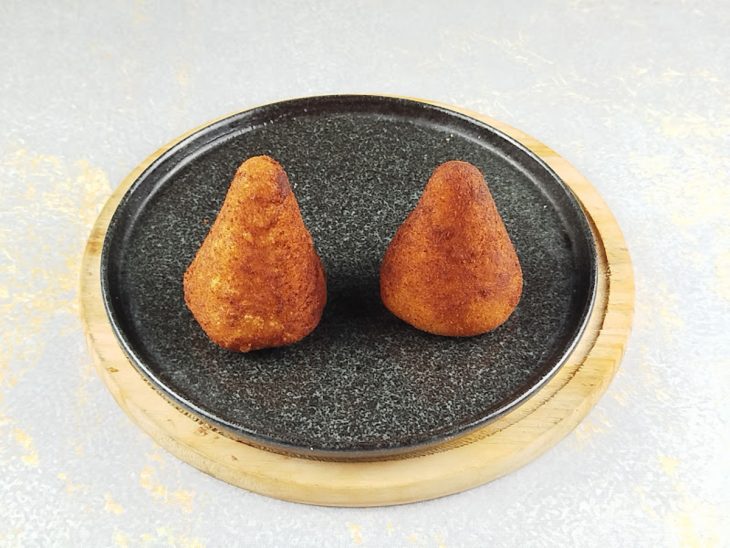 Coxinhas fritas acomodadas num prato.