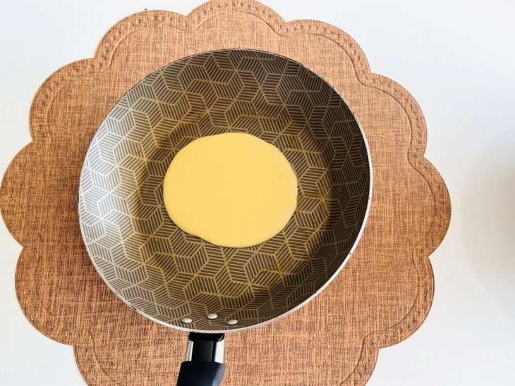 Massa de crepe despejada na frigideira.