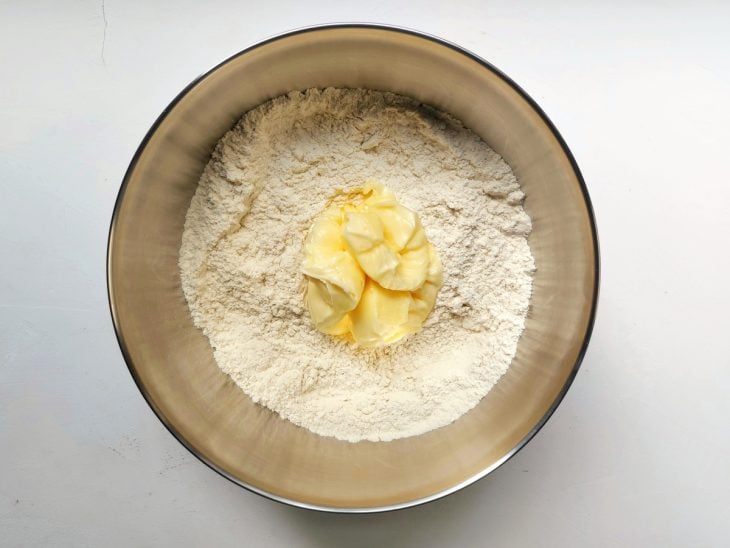 Um recipiente contendo farinha de trigo, manteiga e sal.